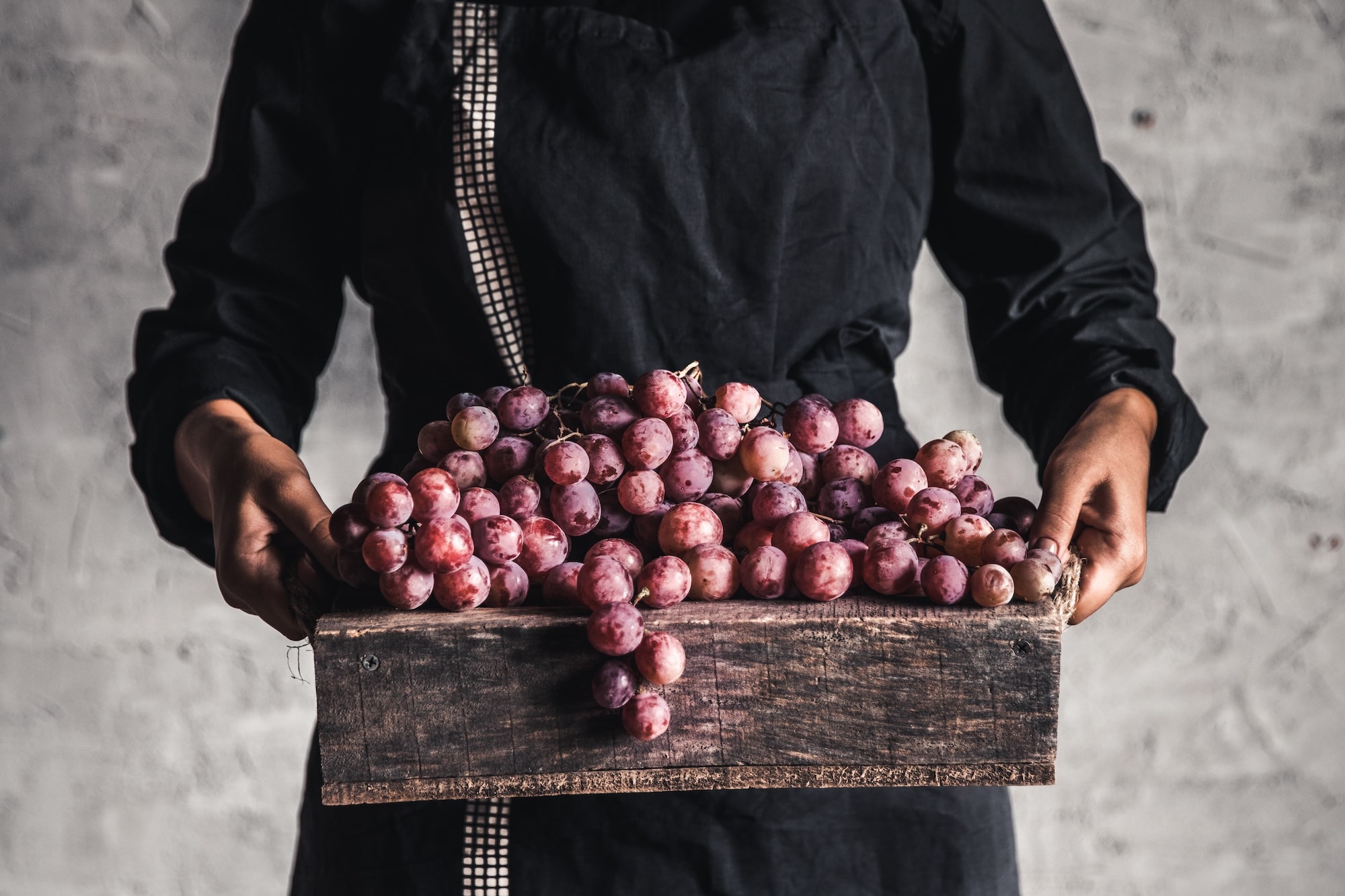 autumn-harvest-fresh-grapes-bunch-wooden-box-ripe-grape-woman-hands-min